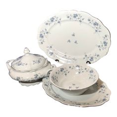 a white and blue dinnerware set with flowers on it