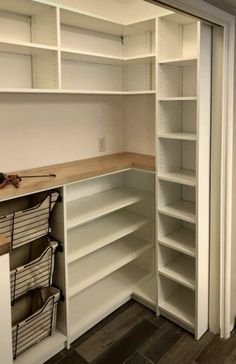 an empty pantry with white shelves and drawers