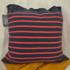 a blue and red striped pillow sitting on top of a wooden table