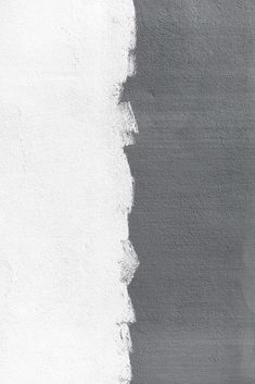 a black and white photo of a wall with paint chippings on it's side