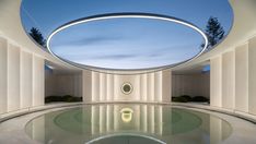 an indoor swimming pool surrounded by columns and circular lights at the end of it's walls