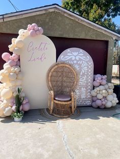 a chair sitting in front of a sign that says celet's love with balloons all around it