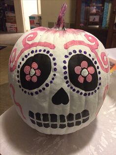 a decorated pumpkin sitting on top of a table