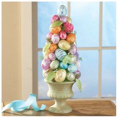 an easter tree made out of eggs on top of a table next to a blue ribbon