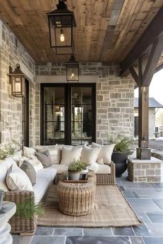 an outdoor living area with couches, tables and lamps on the ceiling is decorated in natural materials