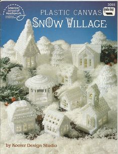 plastic canvass snow village book with white houses and trees in the snow, surrounded by pine cones