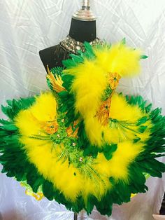 a mannequin with yellow and green feathers on it