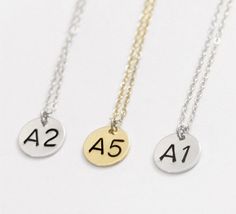 three gold and silver necklaces with numbers on them