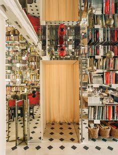 a room filled with lots of books next to a tall book shelf full of books