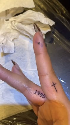 a person with a cross tattoo on their left hand and the word jesus written on it