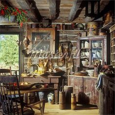 an old fashioned kitchen with lots of clutter on the table and chairs in it