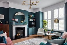 a living room filled with furniture and a fire place in front of a mirror on the wall