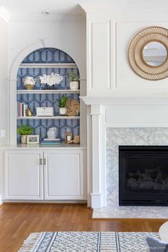 a living room filled with furniture and a fire place in front of a white fireplace