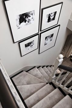 stairs with pictures hanging on the wall above them