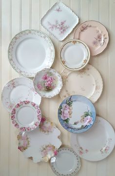 an assortment of china plates and saucers on a wall