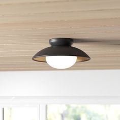 a ceiling light that is hanging from the ceiling in a room with wood paneling