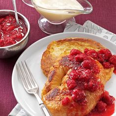 two pieces of french toast on a plate with raspberry sauce next to it