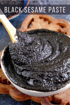 homemade black sesame paste in a white bowl on a wooden spoon with text overlay