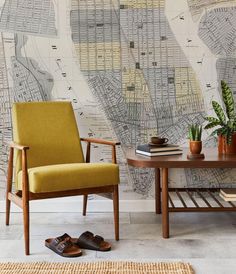 a yellow chair sitting in front of a wall with a map on it's side