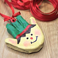 a rock with a hand painted on it next to a red ribbon and some other items