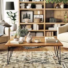 a living room with two couches and a coffee table in front of a bookshelf