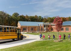 children are lined up to get on the school bus