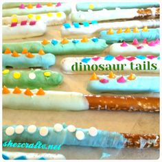 dinosaur tails made out of doughnuts sitting on a table with sprinkles