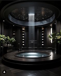 a large circular bathtub in a bathroom with lights on the ceiling and potted plants next to it