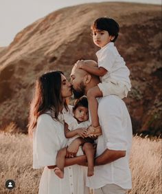 a man and woman holding two children in their arms