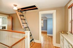 a ladder that is next to a window in a room with wood floors and white railings