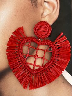 a close up of a pair of red earrings on a woman's neck and ear