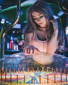 a young woman is playing a game on a pinball table in a bar or casino