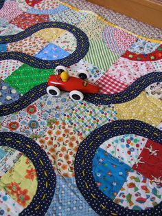 a colorful quilt with a toy car on it