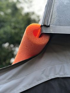 an orange piece of material sticking out of the back of a man's jacket