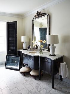 a bathroom with a vanity, mirror and two lamps on the side tables in front of it