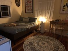 a dog laying on a bed in a room with wood flooring and rugs