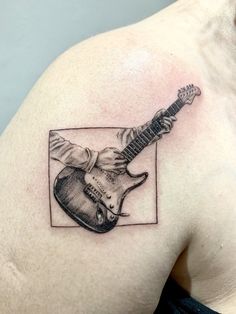 a man with a guitar tattoo on his shoulder