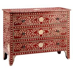 a red and gold painted chest of drawers with two drawers on each side, one drawer closed