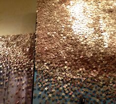 the wall is covered in many different pieces of gold and silver confetti flakes