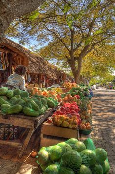 there are many different fruits and vegetables on display at the street side market stall,