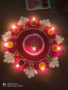 a decorated diya with lit candles on the floor