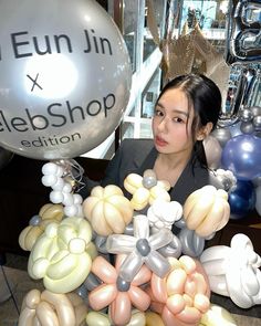 a woman standing in front of balloons at a store