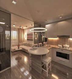 a living room and kitchen area with wood flooring, white furniture and lights on the ceiling