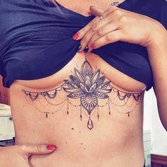 a woman is showing off her stomach tattoo