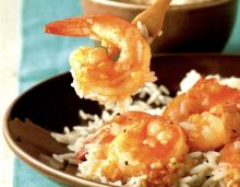 some shrimp and rice on a brown plate