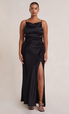 a woman wearing a black dress with a slit