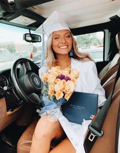 a woman sitting in the back seat of a car holding flowers