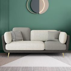 a living room with green walls and a white couch in front of a circular mirror