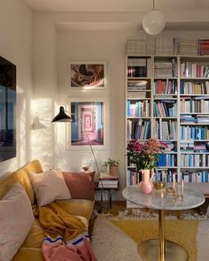 a living room filled with lots of books and furniture