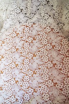 two bedspreads with white and brown flowers on them, one is made from lace